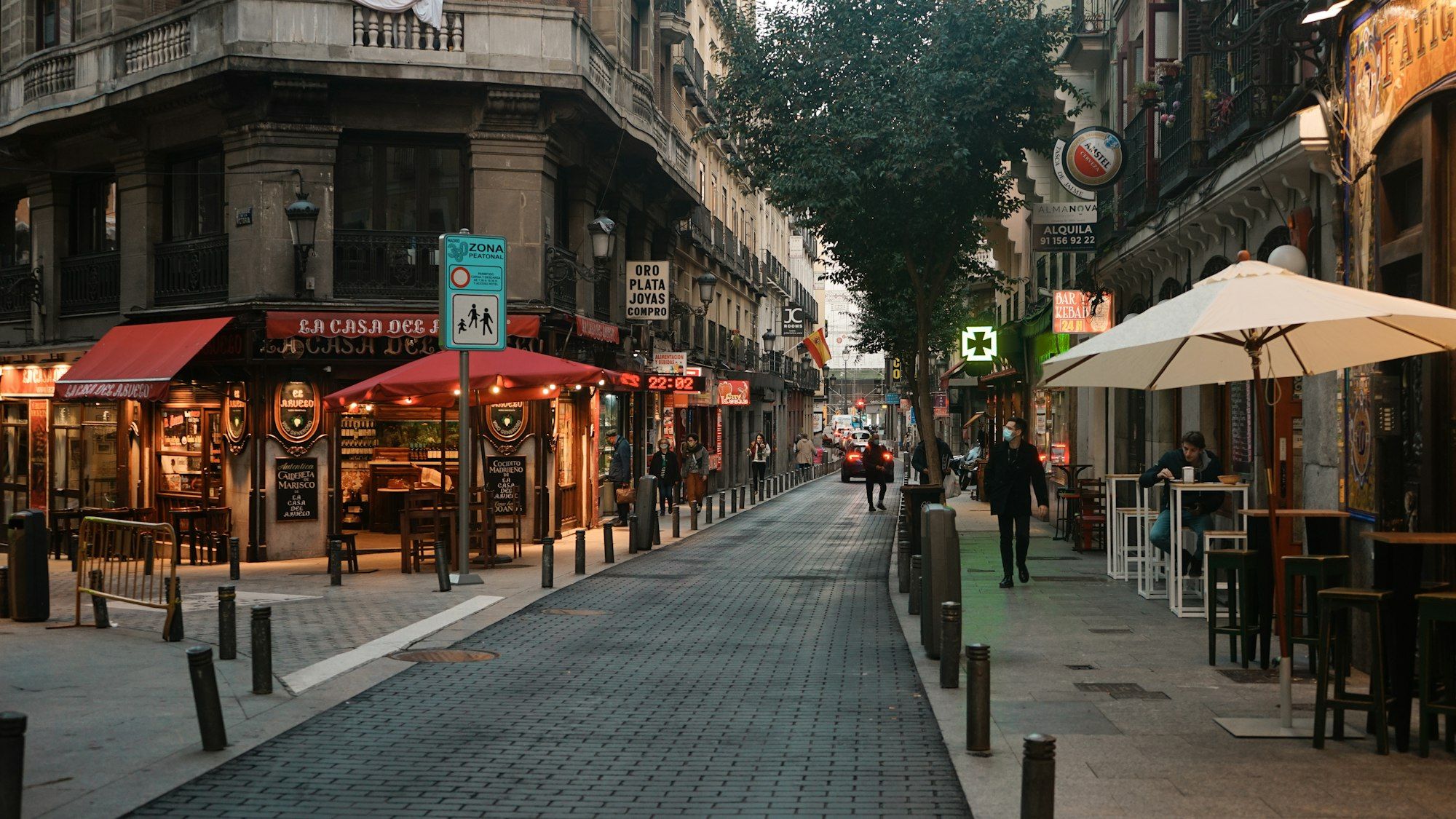 People walking past red-brick buildings, Madrid