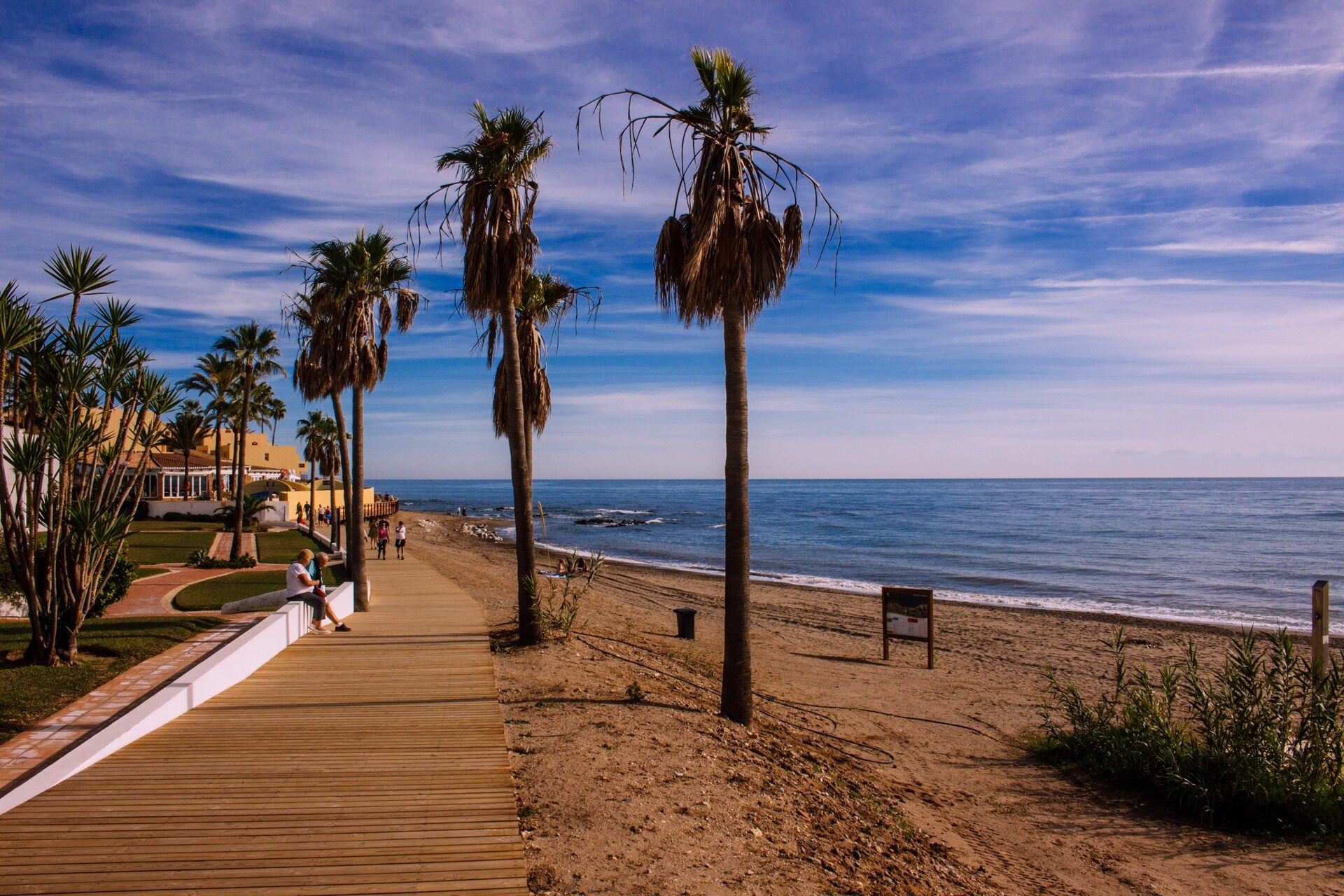 A wooden boardwalk along a beach at dusk