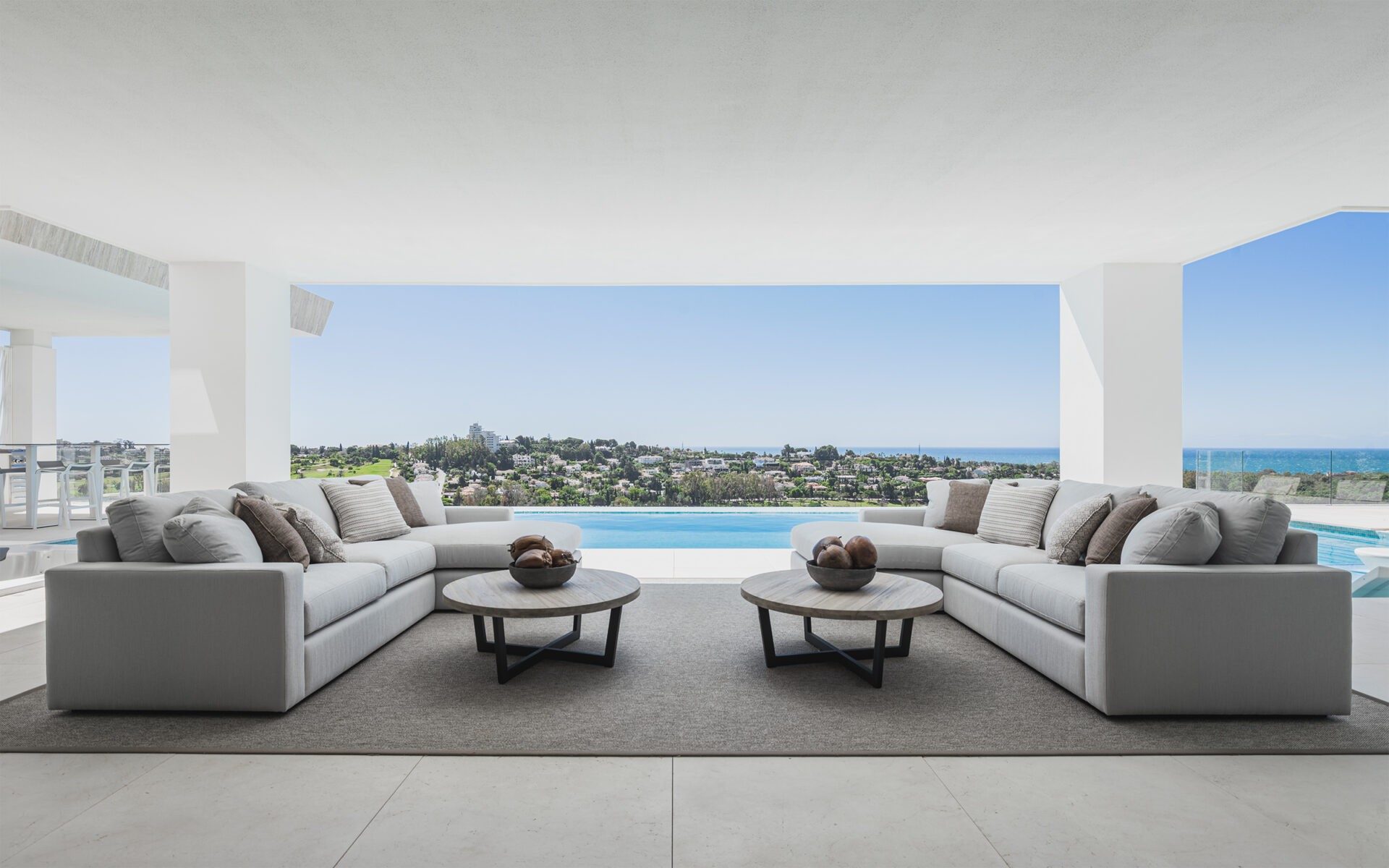A covered terrace with sofas and a sea view in Estepona