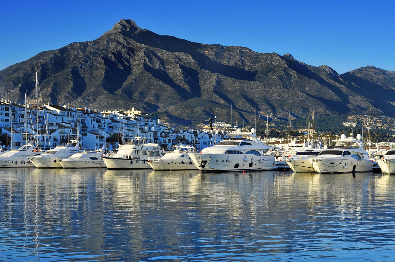 Yachts moored in Puerto Banús marina under La Concha
